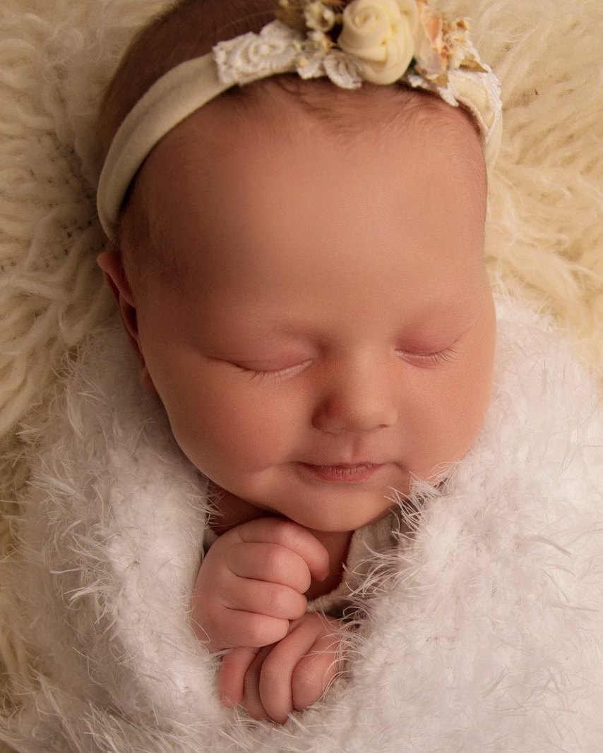 Sleeping newborn baby girl with a floral headband